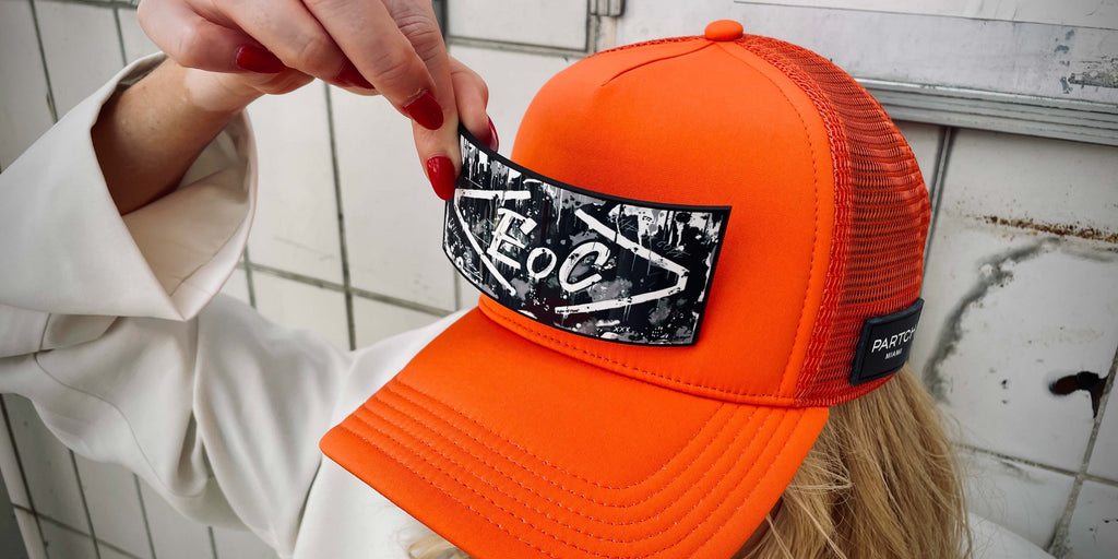 PARTCH Trucker Hat in Orange End of Code logo