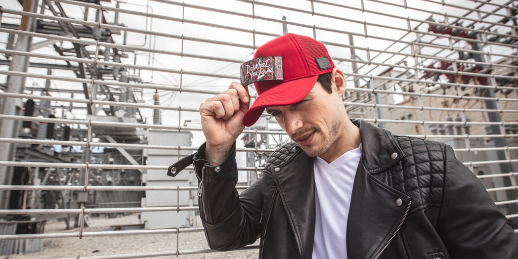 Man with red trucker hat Partch and a luxury leather jacket in black 