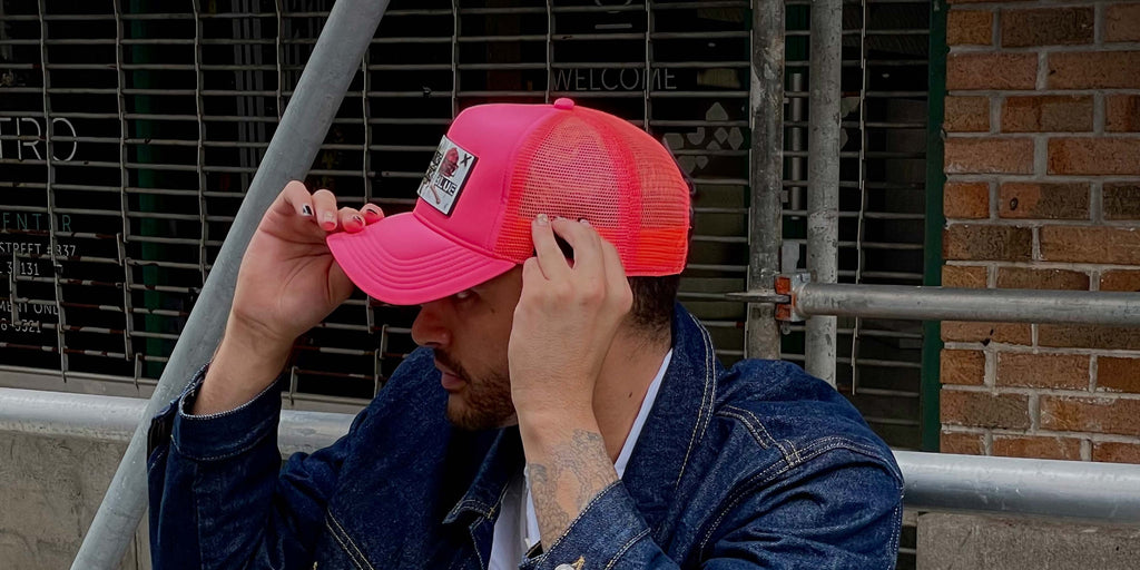 Man wearing Partch hot pink trucker hat with removable patch Art roses
