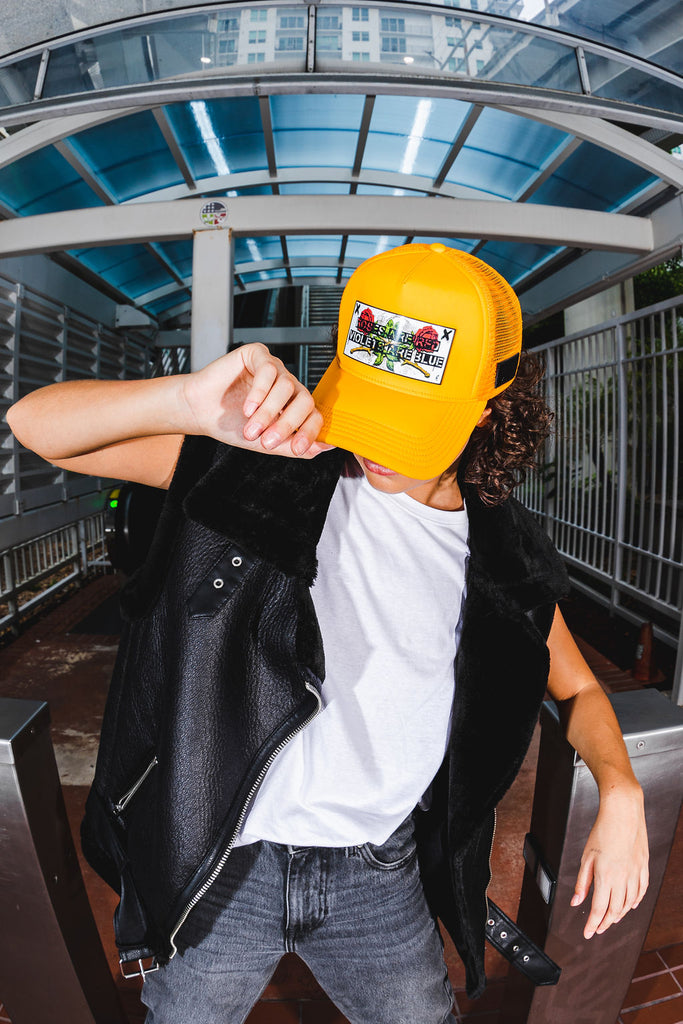 Woman yellow trucker hat Partch and black fashion jacket black