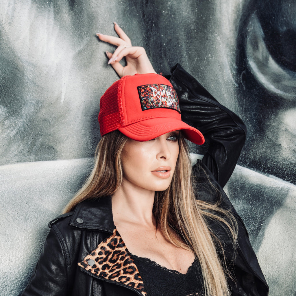 Woman with red trucker hat and leather jacket and panther design